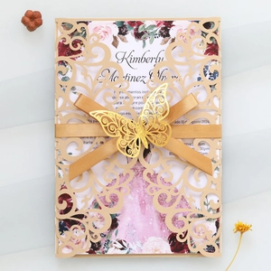 Détail de l'invitation dorée découpée au laser avec insert fleuri et ruban élégant