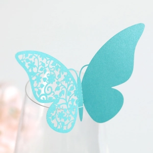 Close-up of a blue butterfly glass card with elegant hollow floral vine paper cutouts