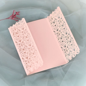 Détail d'invitation de mariage rose découpée au laser avec motifs floraux et design à trois volets