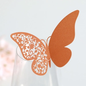 Macro detail of laser-cut butterfly place card with intricate floral patterns on glass