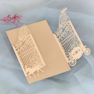 Detailed laser-cut champagne gold wedding invitation featuring carriage and gate patterns