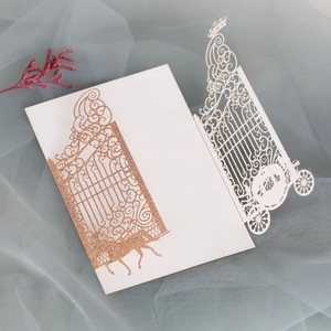 Detailed laser-cut wedding invitation featuring a pumpkin carriage and elegant gates