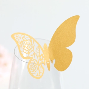 Dettaglio di un segnaposto a farfalla glitter oro tagliato a laser sul calice