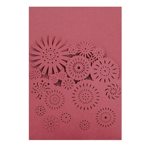 Detail of laser-cut floral pattern on deep red wedding invitation card paper