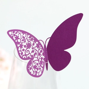 Macro detail of laser-cut purple butterfly wine glass card with intricate floral patterns