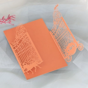 Detail of laser-cut orange-red wedding invitation with elegant horse carriage design