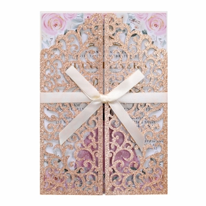 Détail du faire-part de mariage ajouré rose doré pailleté avec ruban et motif floral