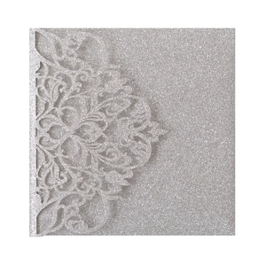 Detail of silver glitter laser-cut wedding invitation with elegant floral hollow patterns
