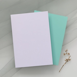 Détail de cartes d'invitation violet clair et bleu sarcelle sur tissu en gaze blanche