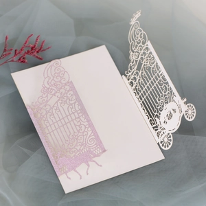 Close-up of laser-cut glitter pink horse gate and white pumpkin carriage wedding invitation