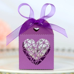 Détail d'une boîte à bonbons violette avec cœur ajouré et ruban en satin pour mariage