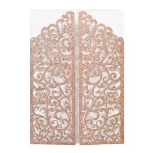 Détail du faire-part de mariage découpé au laser en or rose avec volutes ajourées