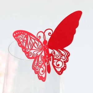 Vue macro d'un papillon en papier découpé au laser pour bord de verre rouge