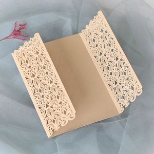 Détails du motif floral doré coupé au laser sur une carte d'invitation de mariage à trois volets