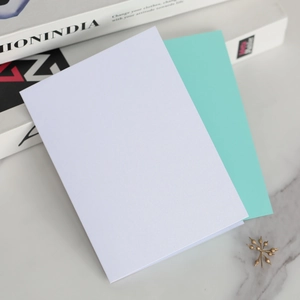 Cartes d'invitation blanc perle et bleu tiffany sur une surface texturée en marbre