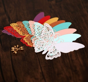 Détail de marque-places papillons découpés au laser en plusieurs couleurs sur du bois