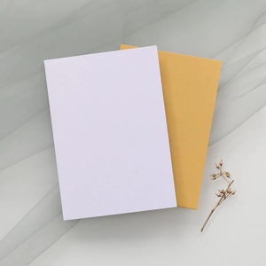 Détail de cartes d'invitation épurées avec décor floral doré et texture élégante