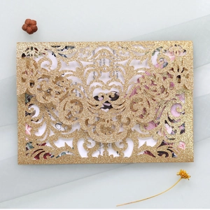 Detailed laser-cut hollow pattern on gold glitter wedding invitation with floral insert card