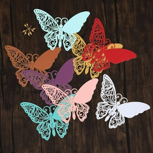 Marque-places papillon découpés au laser en plusieurs couleurs sur fond bois sombre