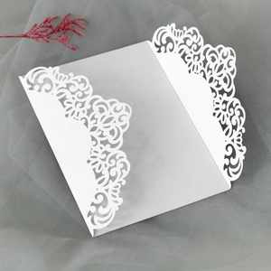 Detail of white laser-cut wedding invitation shell with elegant floral hollow patterns