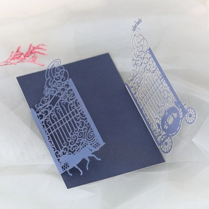 Detail of laser-cut navy blue wedding invitation featuring carriage and gate designs