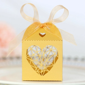 Détail de boîte à bonbons dorée cœur évidé avec texture métallique et ruban