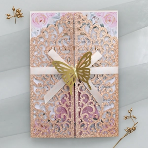 Détail de l'invitation de mariage découpée au laser or rose avec ruban et papillon