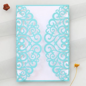 Détail macro d'une invitation de mariage bleu clair découpée au laser avec motifs dentelle