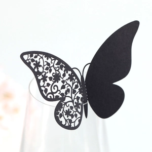 Macro detail of laser-cut black butterfly card with intricate floral hollow patterns