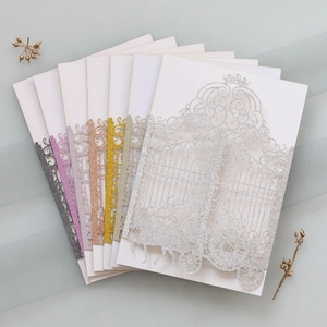 Macro shot of laser-cut glitter wedding cards featuring a pumpkin carriage design