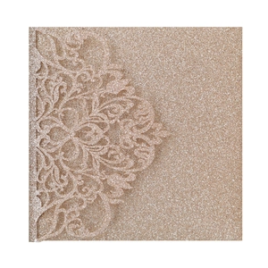 Macro shot of rose gold glitter cardstock with laser-cut mandala lace for wedding invitation