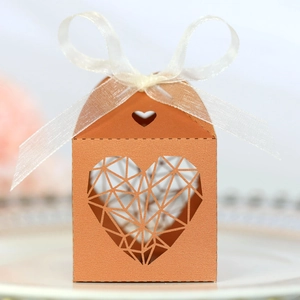 Détail de la boîte à dragées de mariage découpée au laser avec motif cœur et ruban blanc