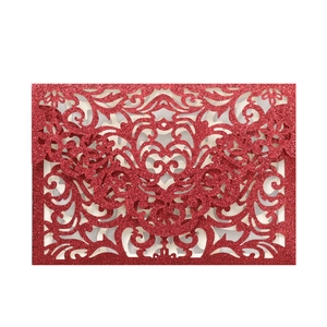 Macro detail of red glitter laser-cut lace pattern on an elegant wedding invitation