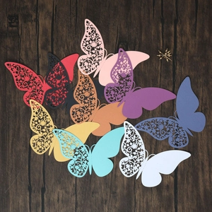 Close-up of laser-cut butterfly place cards in various colors for wine glass decor