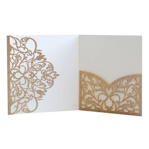 Detail of laser-cut gold glitter wedding invitation with elegant symmetrical floral hollows