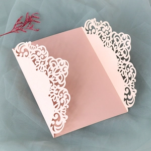 Detail of light pink laser cut invitation card with elegant floral lace patterns