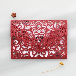 Detailed laser cut red glitter wedding invitation with elegant baroque floral patterns