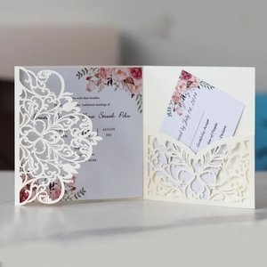 Nahaufnahme der lasergeschnittenen Hochzeitseinladung mit Blumendruck und RSVP-Karte