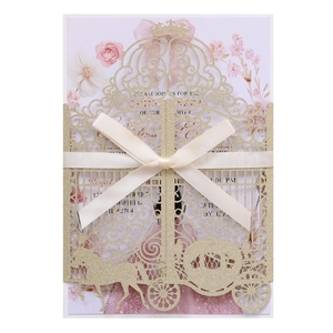 Detail of laser-cut gold glitter wedding invitation with pumpkin carriage and ribbon