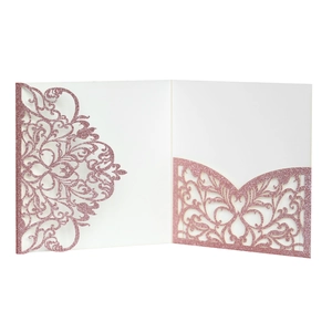 Detail of laser-cut wedding invitation with rose gold glitter filigree pattern