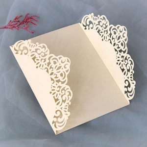 Detail view of cream laser-cut wedding invitation cover with elegant European scroll patterns