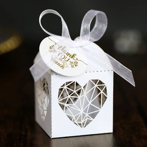 Détail de boîte de mariage blanche découpée au laser avec motif cœur et étiquette