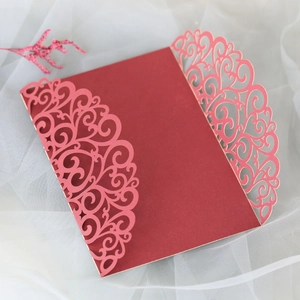 Détail de l'invitation de mariage rouge découpée au laser avec motifs floraux élégants