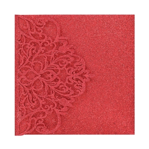 Close-up of red glitter laser-cut wedding invitation with baroque floral patterns