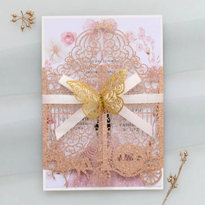 Macro detail of laser-cut rose gold wedding invitation with ribbon and butterfly