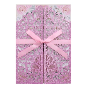 Détail d'invitation de mariage découpée au laser avec ruban rose et motifs floraux