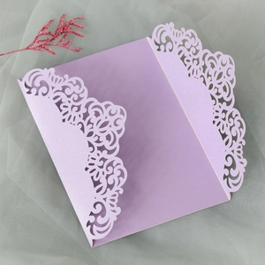 Macro detail of laser-cut purple pearl paper invitation cover with floral pattern
