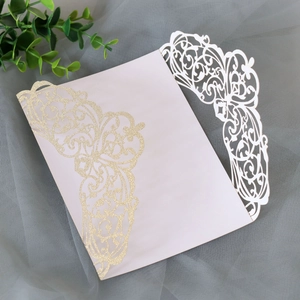 Detailed laser-cut glitter gold wedding invitation cover with intricate floral hollow patterns