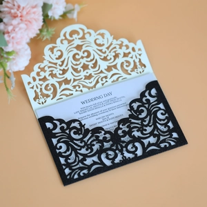 Elegant laser-cut wedding invitation card with black glitter and cream floral hollow design