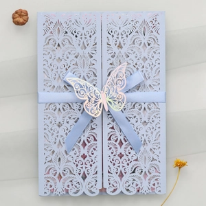 Détail de l'invitation de mariage bleu clair découpée au laser avec ruban et papillon